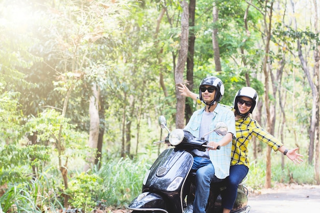 Couple chevauchant leur scooter à travers la forêt. concept d&#39;idée de style de vie