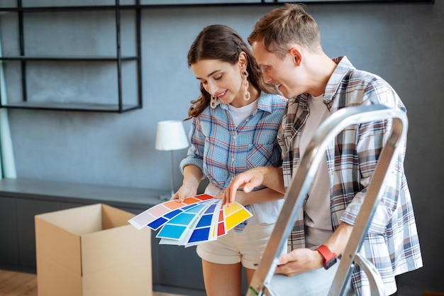 Couple choisissant la couleur des meubles dans une nouvelle maison