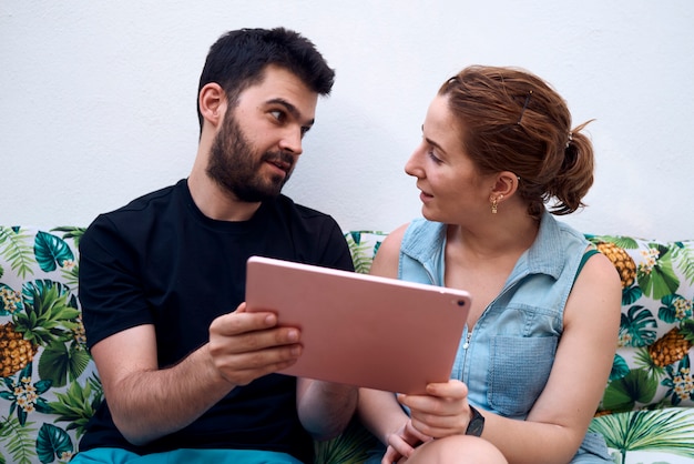 Couple choisissant une destination de vacances à l'aide d'une tablette