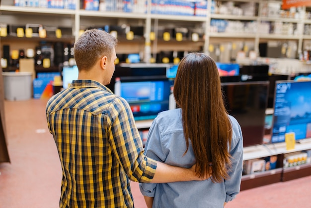 Couple choisissant la télévision en magasin d'électronique