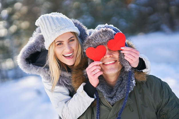 Couple avec des coeurs rouges dans un paysage enneigé d'hiver. photo de haute qualité