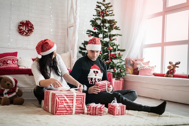 Couple avec coffrets cadeaux assis sur le sol