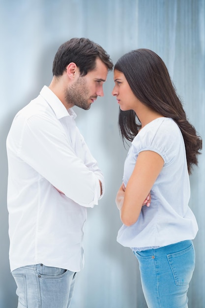 Couple en colère face à face après une dispute sur fond de planches de bois blanchies