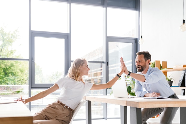 Couple de collègues heureux donnant cinq