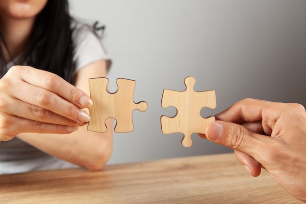 Un couple connecte des pièces de puzzle près de la table