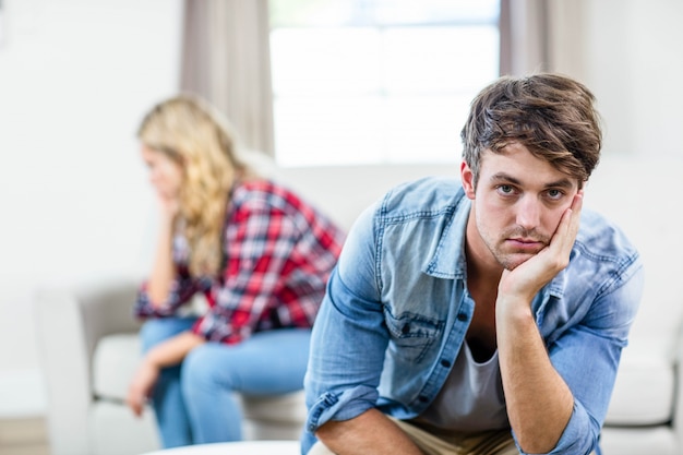 Couple contrarié en train de bouder dans le salon