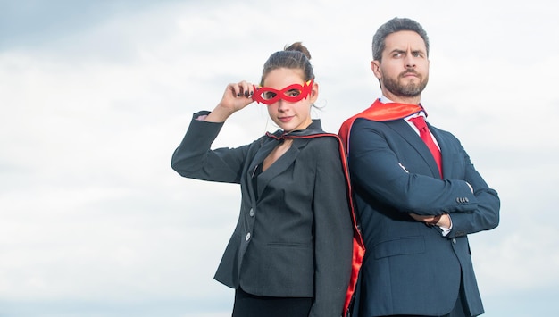 Couple en costume de super-héros sur fond de ciel défi commercial