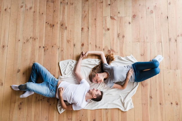 Couple, coucher plancher, et, tenant mains