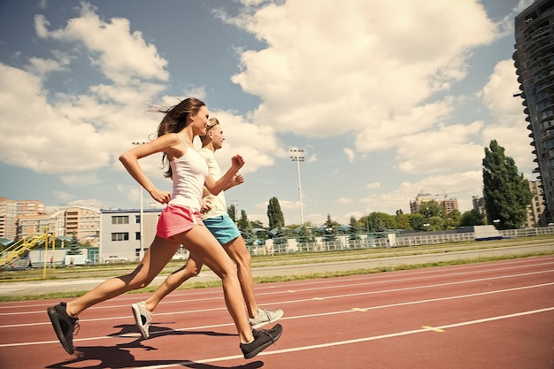 Couple de coureurs en plein air ensoleillé Femme et homme courent sur le stade Activité et énergie Entraînement et entraînement à l'air frais Sport santé et bien-être