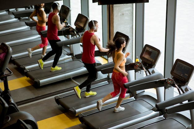 Couple courir sur des tapis de course dans le gymnase