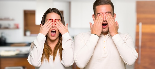 Couple couvrant les yeux à la main dans une maison