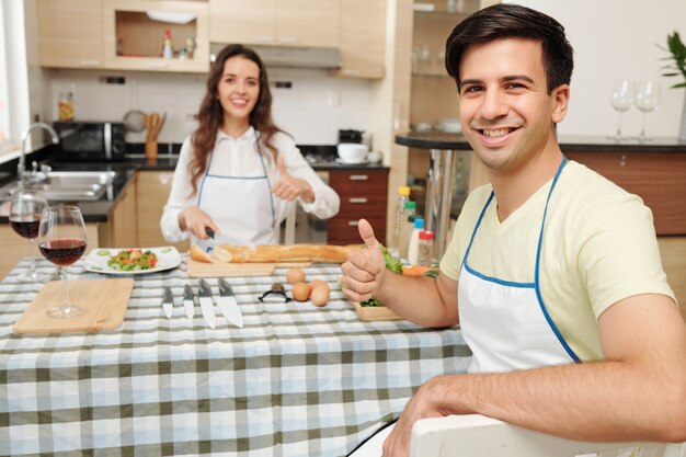 Couple de cuisine montrant les pouces vers le haut