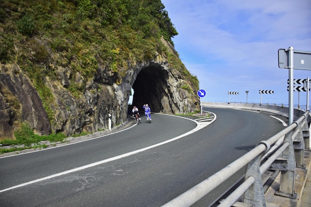Un couple de cyclistes quittent le tunnel le long de la côte Le Chemin du Nord de St James Espagne