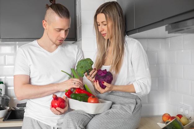 Photo couple dans la cuisine en choisissant des légumes