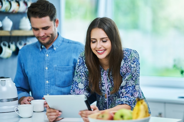 couple dans la cuisine à domicile à l'aide d'une tablette électronique