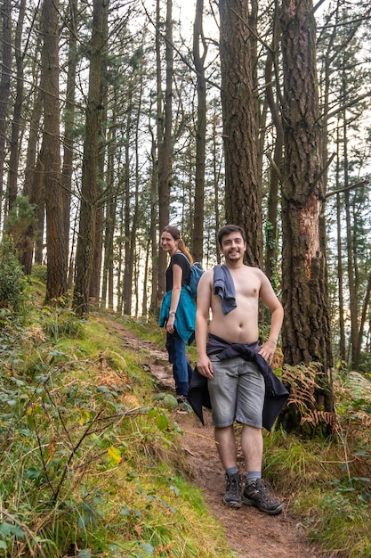 Un couple dans la forêt de hêtres sur le chemin du mont Adarra dans la ville d'Urnieta