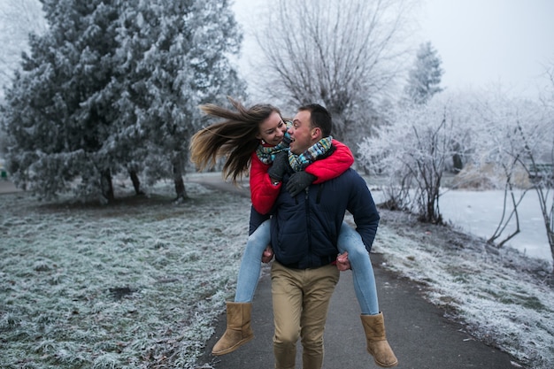 Couple dans la forêt d'hiver près du lac