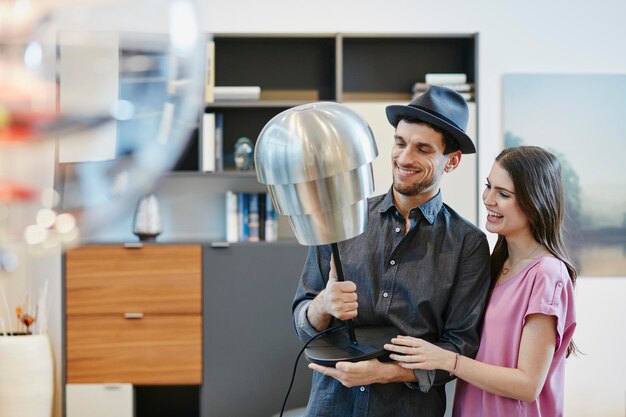 Couple dans un magasin de meubles choisissant une lampe