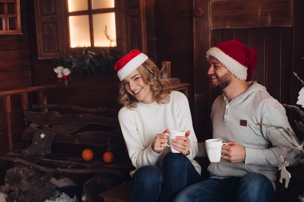 Couple dans les mêmes vêtements chauds avec des chapeaux rouges et blancs par temps de neige