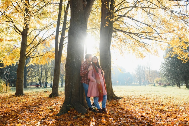 Couple dans le parc en automne. Homme et femme souriants à l'extérieur.