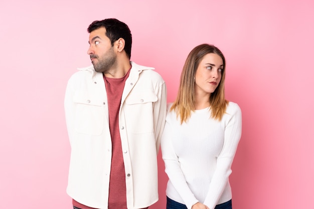 Couple dans la Saint-Valentin sur mur rose isolé nerveux et effrayé