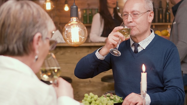 Couple dans la soixantaine buvant du vin alors qu'ils sont dans un restaurant pour déjeuner. Couple romantique. Couple de personnes âgées.