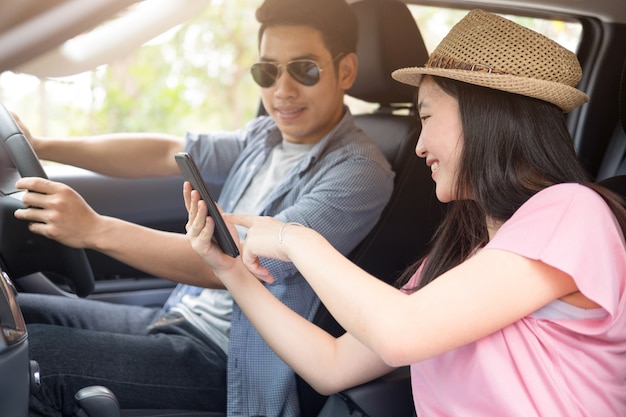 Couple dans la voiture avec carte. L&#39;homme au volant.