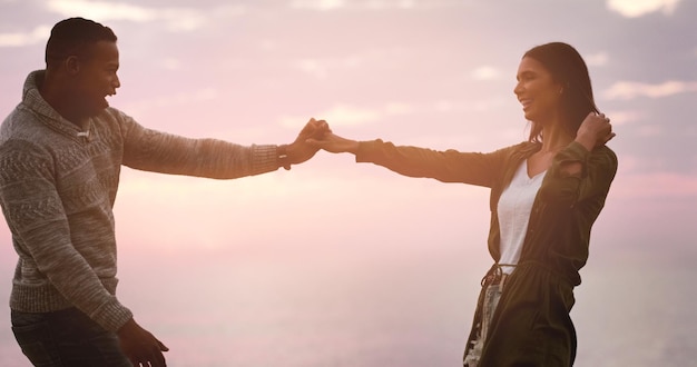 Photo couple dansant et ciel coucher de soleil à la plage pour un souvenir heureux en vacances ou à l'aventure un homme et une femme dansent pour célébrer le mariage d'amour et le voyage ou rendez-vous avec un sourire en plein air dans la nature