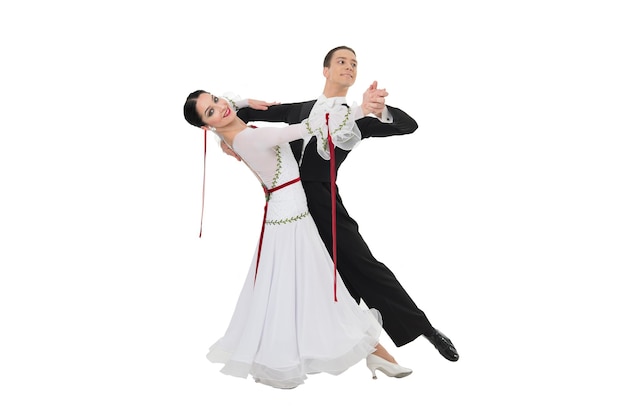 Couple de danse danse dans une pose de danse isolé sur fond blanc. danseurs professionnels sensuels dansant la valse, le tango, le slowfox et le quickstep.