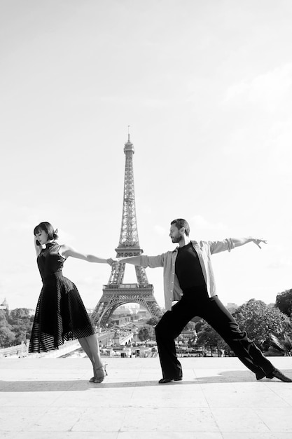 Couple de danse devant la tour eifel à paris france beatuiful couple de danse de salon en danse pose près de la tour eifel concept de voyage romantique sentiment sensuel et amour