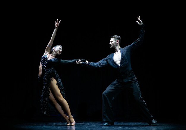 Couple de danse de salon isolé sur fond noir.