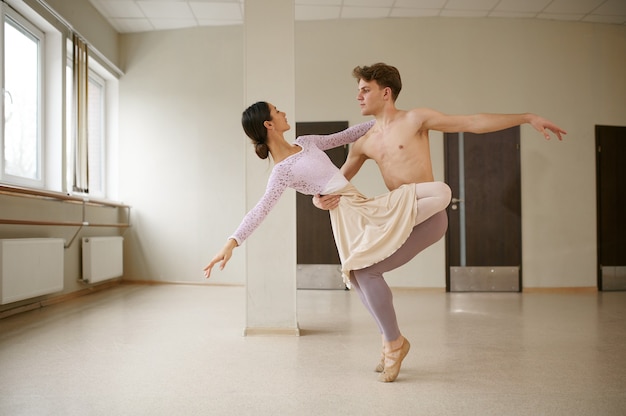 Couple de danseurs de ballet, dansant en action. Ballerine avec formation de partenaire en classe, intérieur du studio de danse