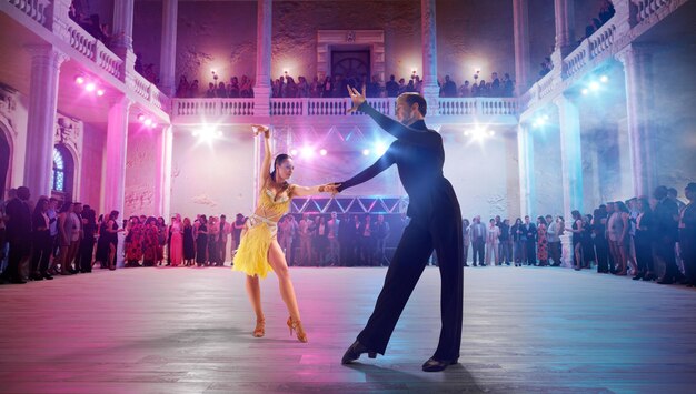 Photo couple de danseurs exécutent la danse latine sur une grande scène professionnelle danse de salon