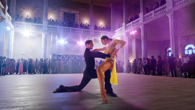 Couple de danseurs exécutent la danse latine sur une grande scène professionnelle danse de salon