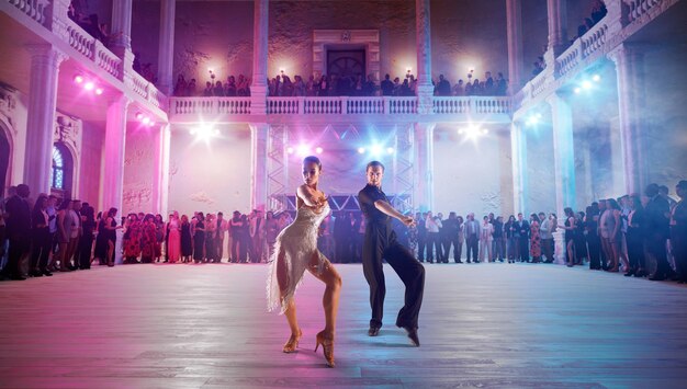 Couple de danseurs exécutent la danse latine sur une grande scène professionnelle danse de salon