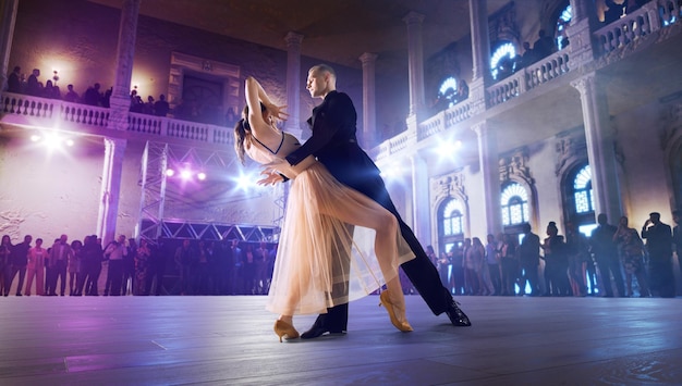 Couple de danseurs interprètent la valse sur une grande scène professionnelle Danse de salon