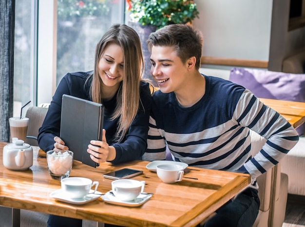 couple datant dans un café Ils s'amusent et sourient avec tablette Dating love