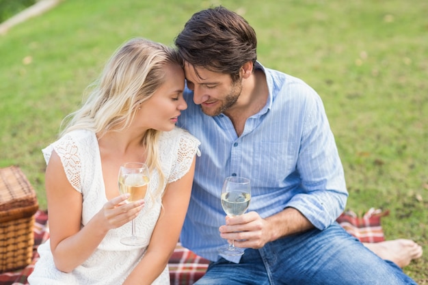 Couple à date tenant des verres à vin blanc