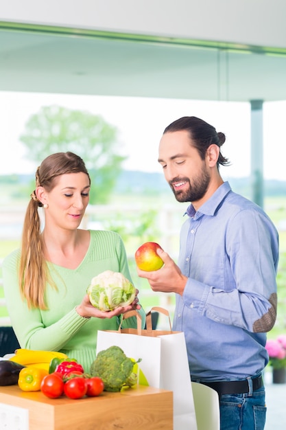 Couple, déballage, sac épicerie, chez soi