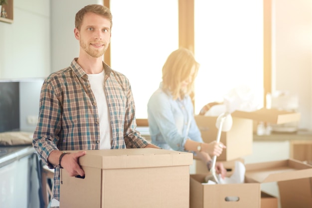 Couple déballant des cartons dans leur nouvelle maison jeune couple