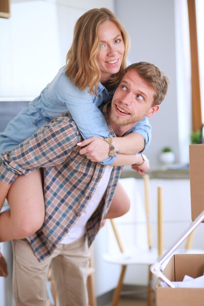 Couple déballant des cartons dans leur nouvelle maison jeune couple