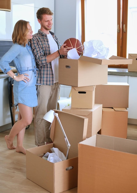 Couple déballant des cartons dans leur nouvelle maison jeune couple