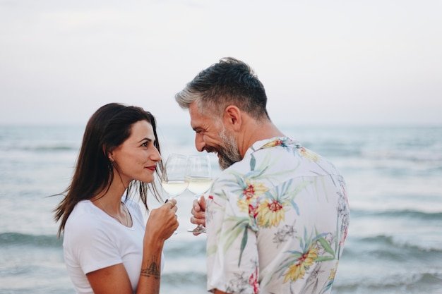 Couple en dégustant un verre de vin au bord de la plage