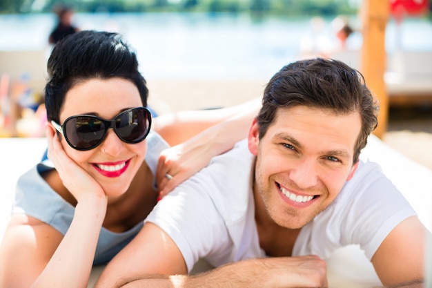 Couple de détente au soleil d&#39;été sur la plage