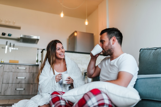 Couple de détente sur le canapé sous couverture à la maison.