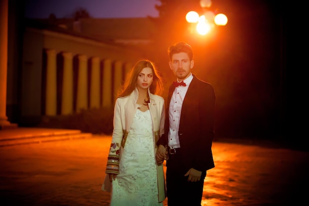 Un couple devant un immeuble la nuit