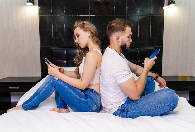 Couple dos à dos avec les smartphones