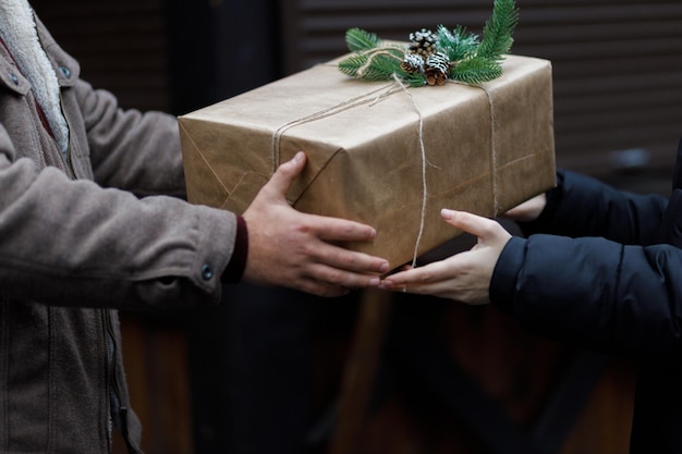 Un couple échange des cadeaux Beau cadeau Décoration du Nouvel An Préparation pour les vacances Cadeau sur fond sombre