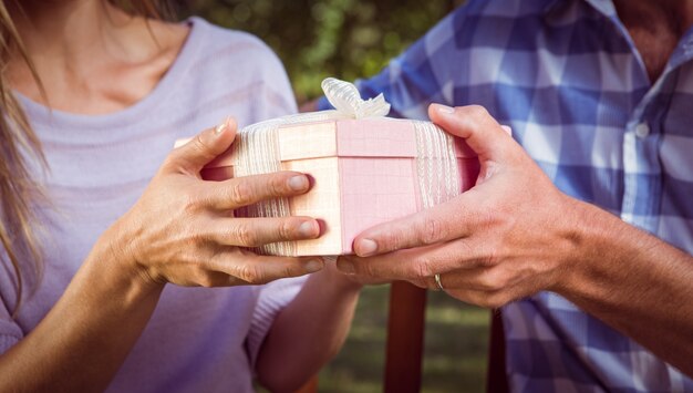 Couple échangeant un cadeau dans le parc