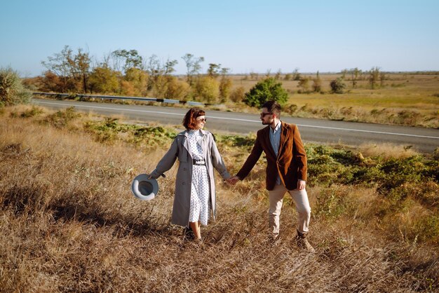 Un couple élégant et amoureux s'amusant à l'extérieur Un couple élégante se promenant et s'embrassant